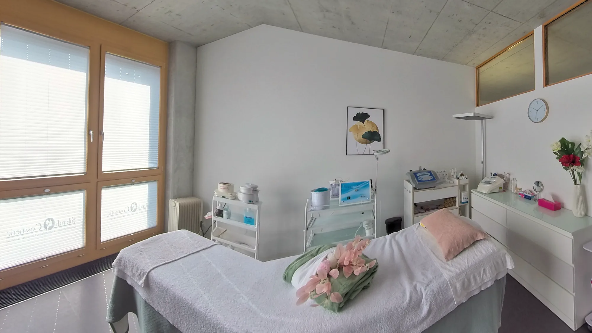 Behandlungsraum von Silendi Cosmetic mit Liege, Geräten für die apparative Kosmetik und grossem Fenster